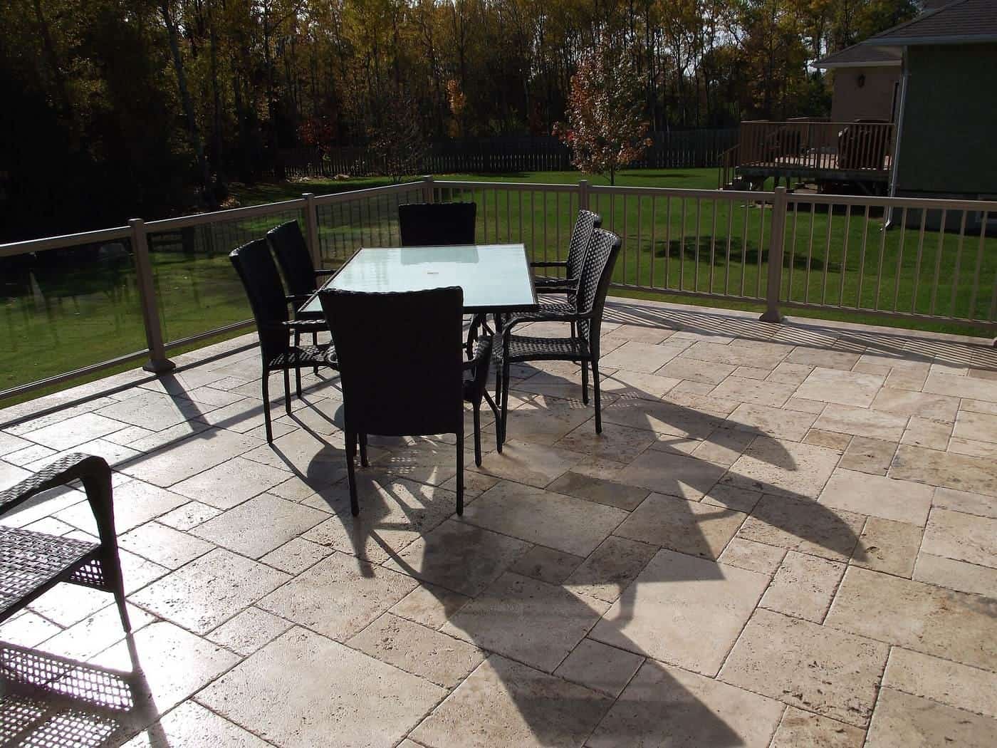 A travertine paved deck around an outdoor area